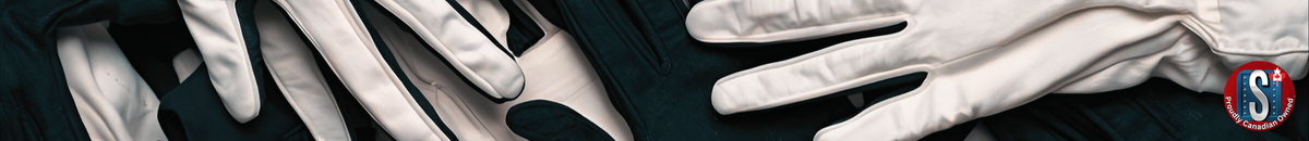 White and black fabric work gloves on a dark surface, representing Skookum Tools' fabric safety gloves category for light duty, assembly, and general work applications.